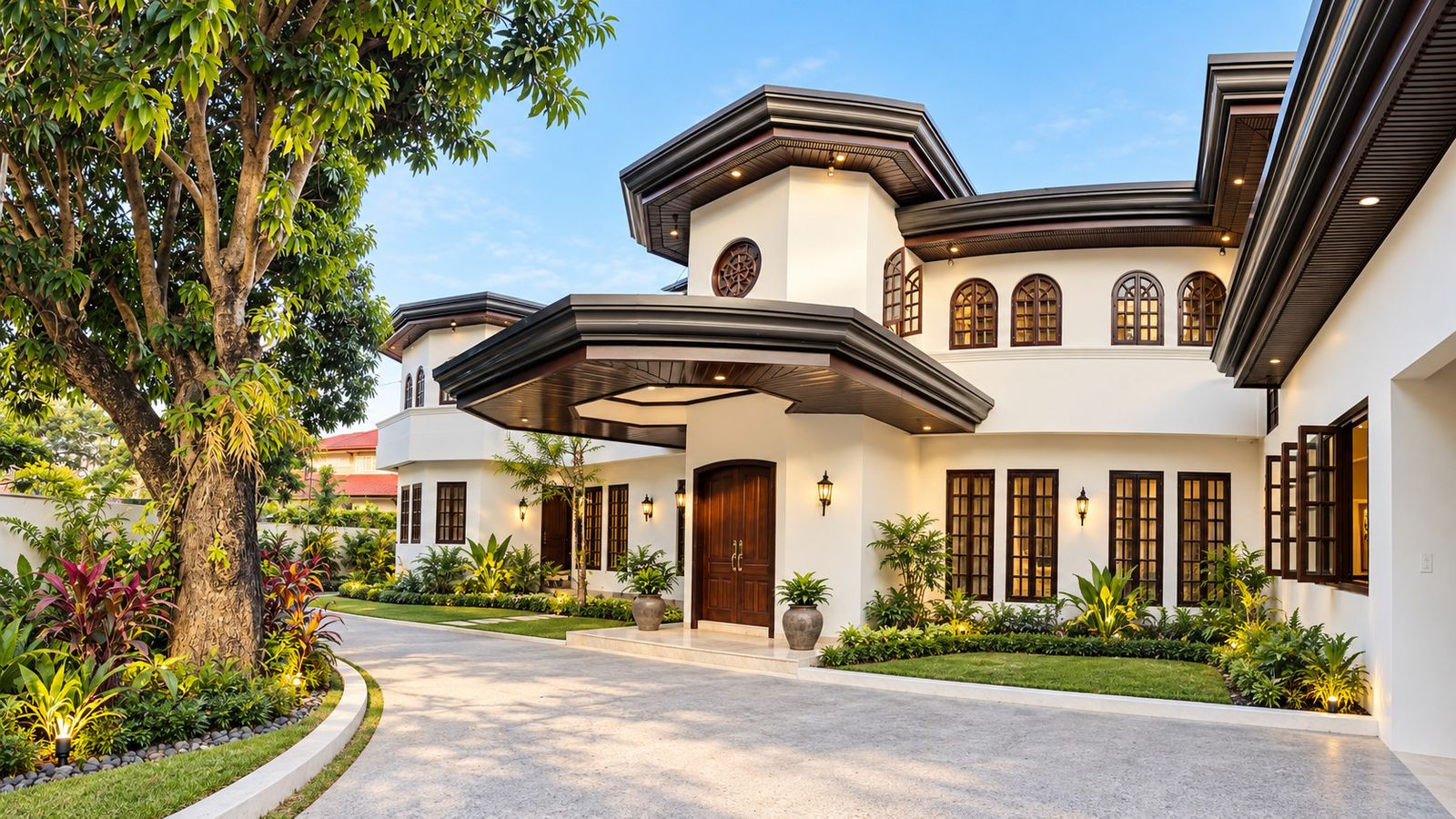 Renovated two-storey residence with arched windows and a landscaped driveway in Ayala Alabang Village